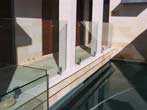 Sandstone surrounds and glass pool fence over indoor lap pool